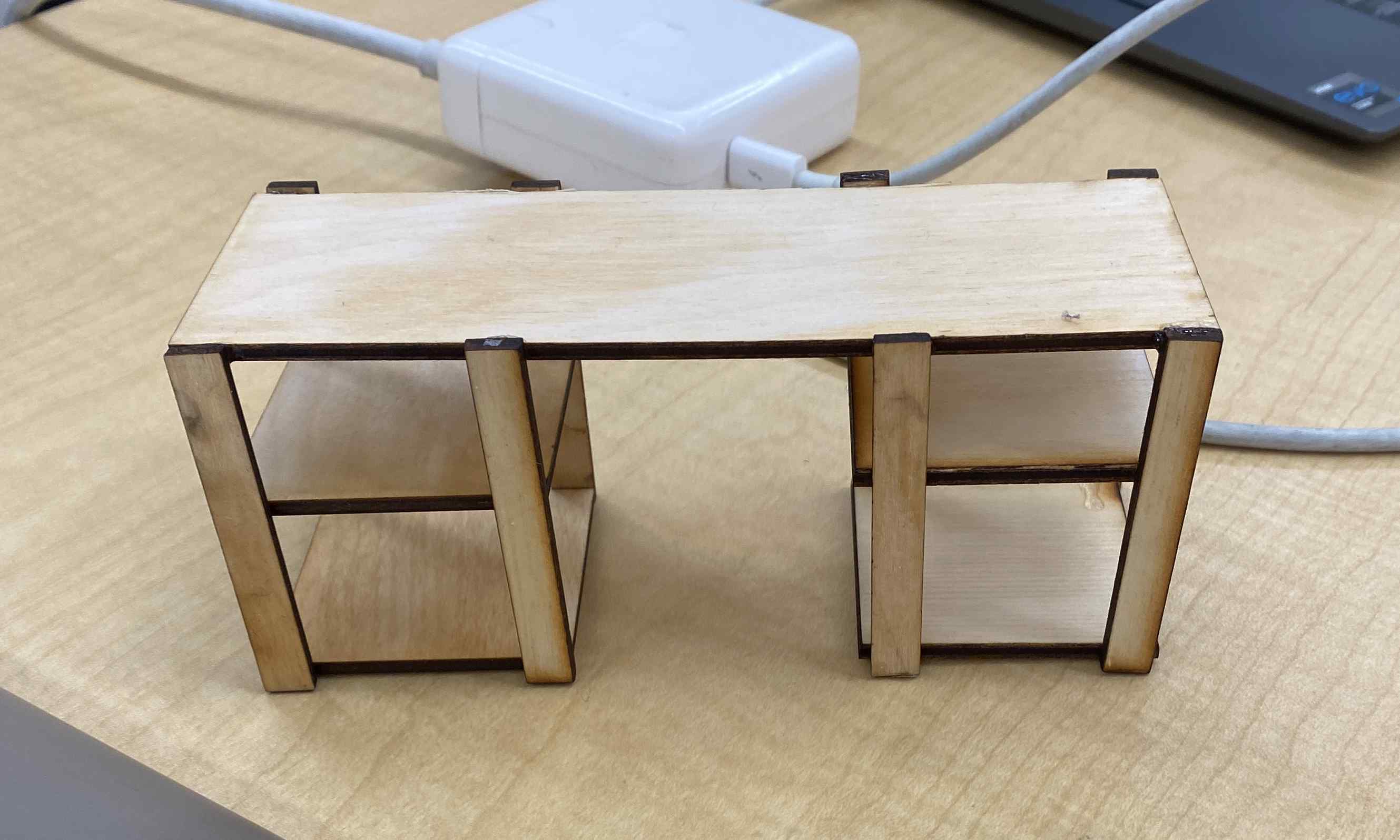 We laser cut wood to make a small model of the desk